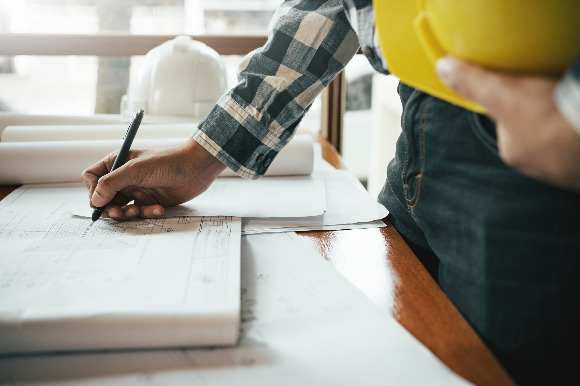 Close-up of asian male civil engineer working on blueprint